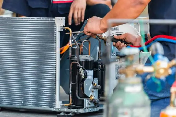Hands repairing internal heating and cooling equipment components